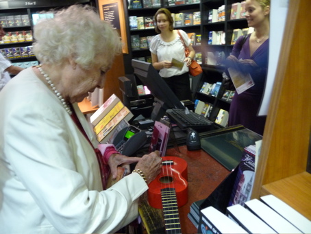 Dame Vera signing Katy's red ukulele